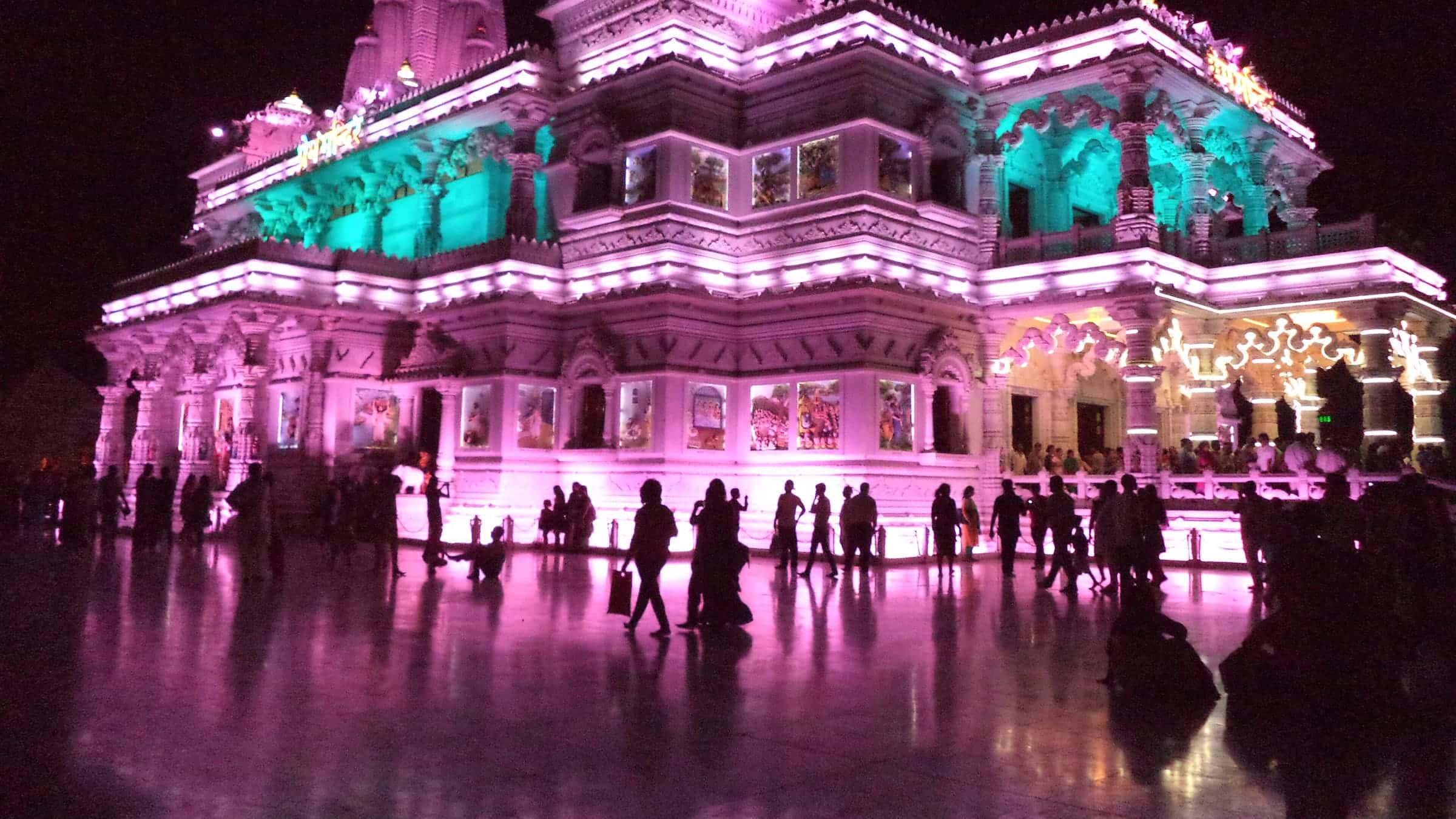 Prem Mandir in Vrindavan lit up in pink and teal at night