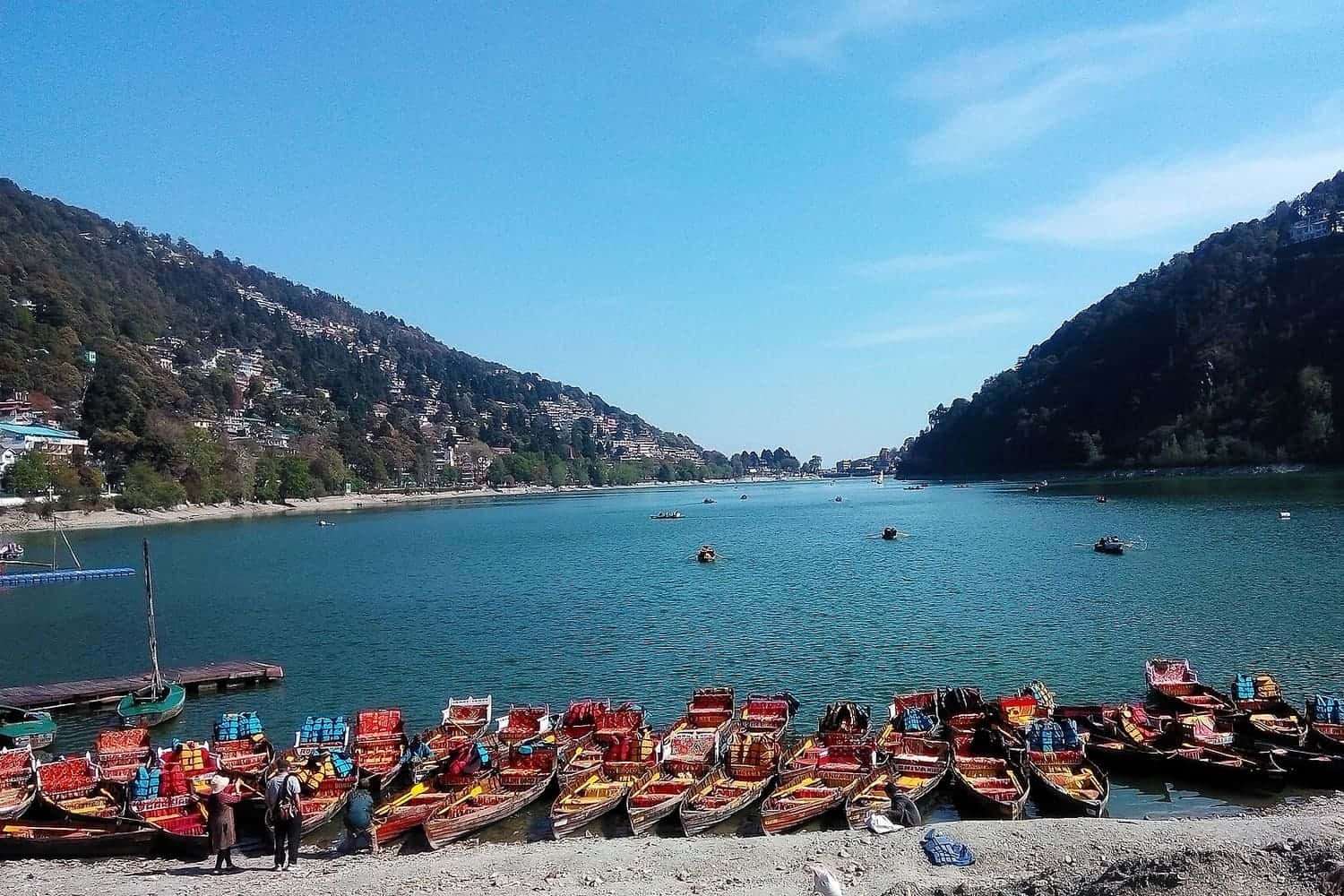 Rowing boats lined up on Naini Lake with hills behind, Nainital