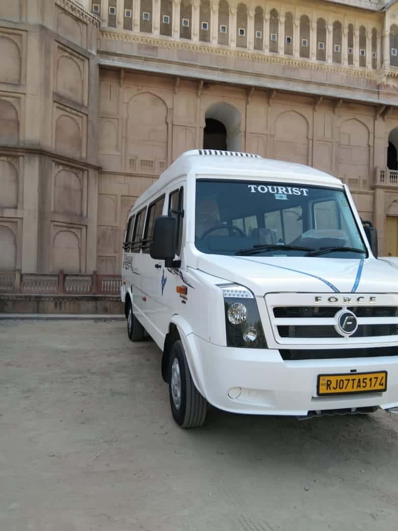 White Force Traveller tourist van parked in front of a sandstone fort palace